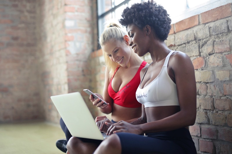 Women in workout clothes in front of laptop